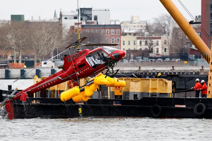 A crane lifts the sightseeing helicopter that crashed into the East River on March 12, 2018